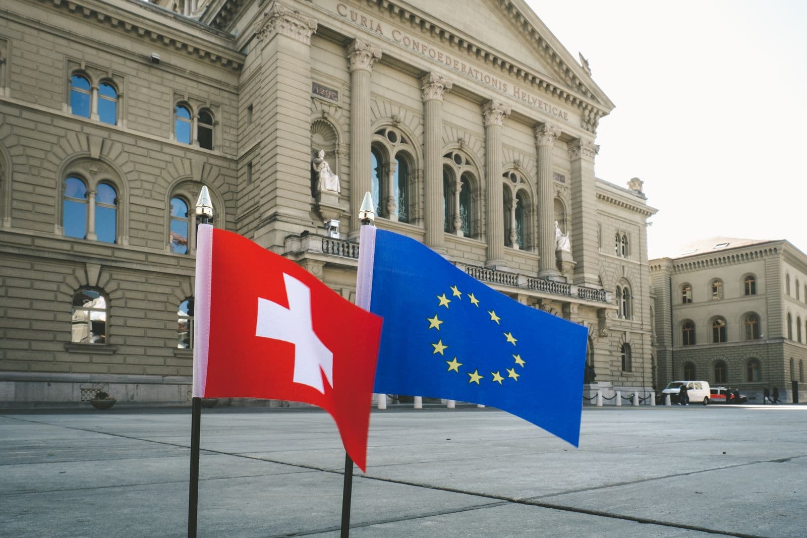 National and European Union flags outside a government building